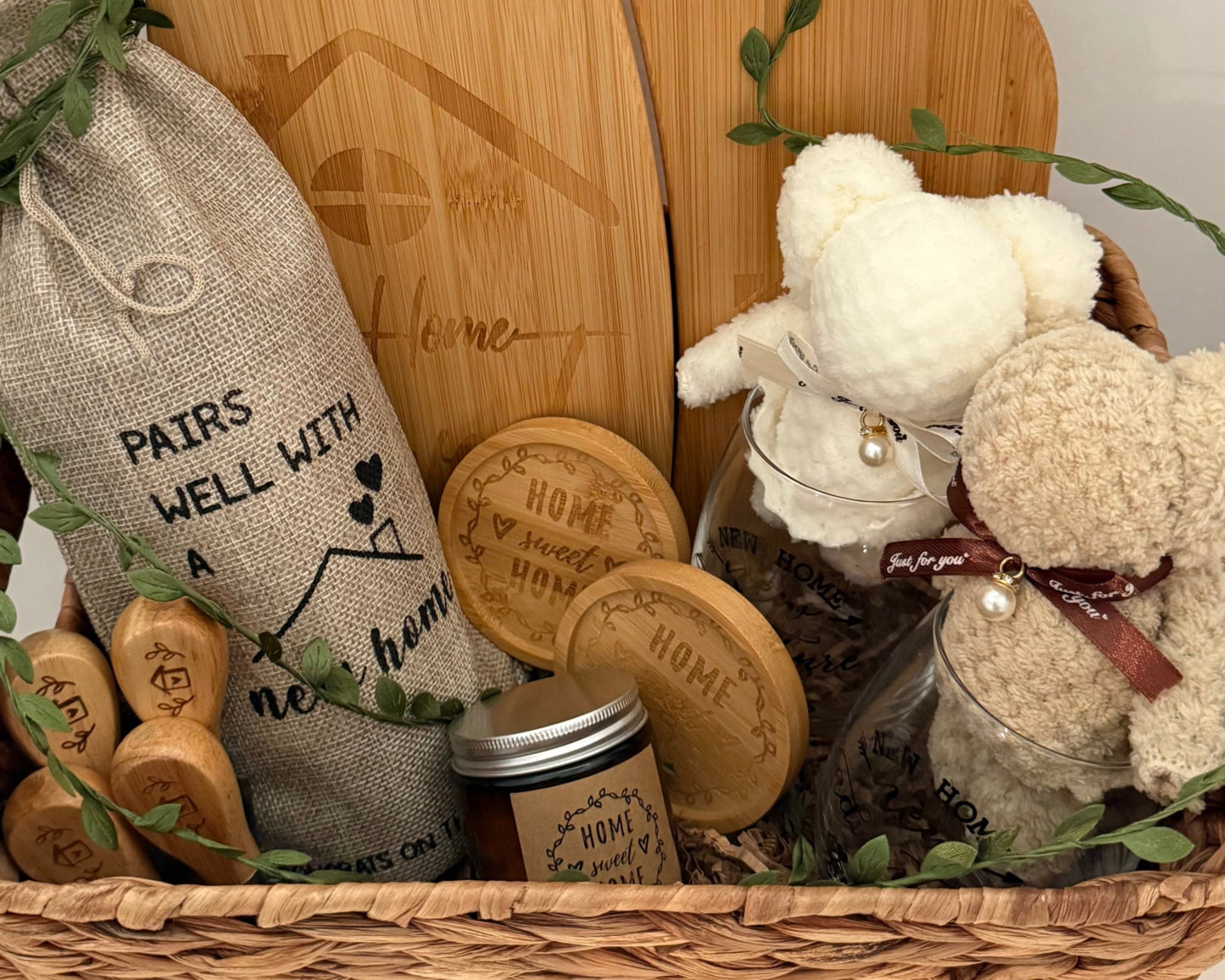 Gift basket with wooden cutting boards, a teddy bear, and other items on a white background