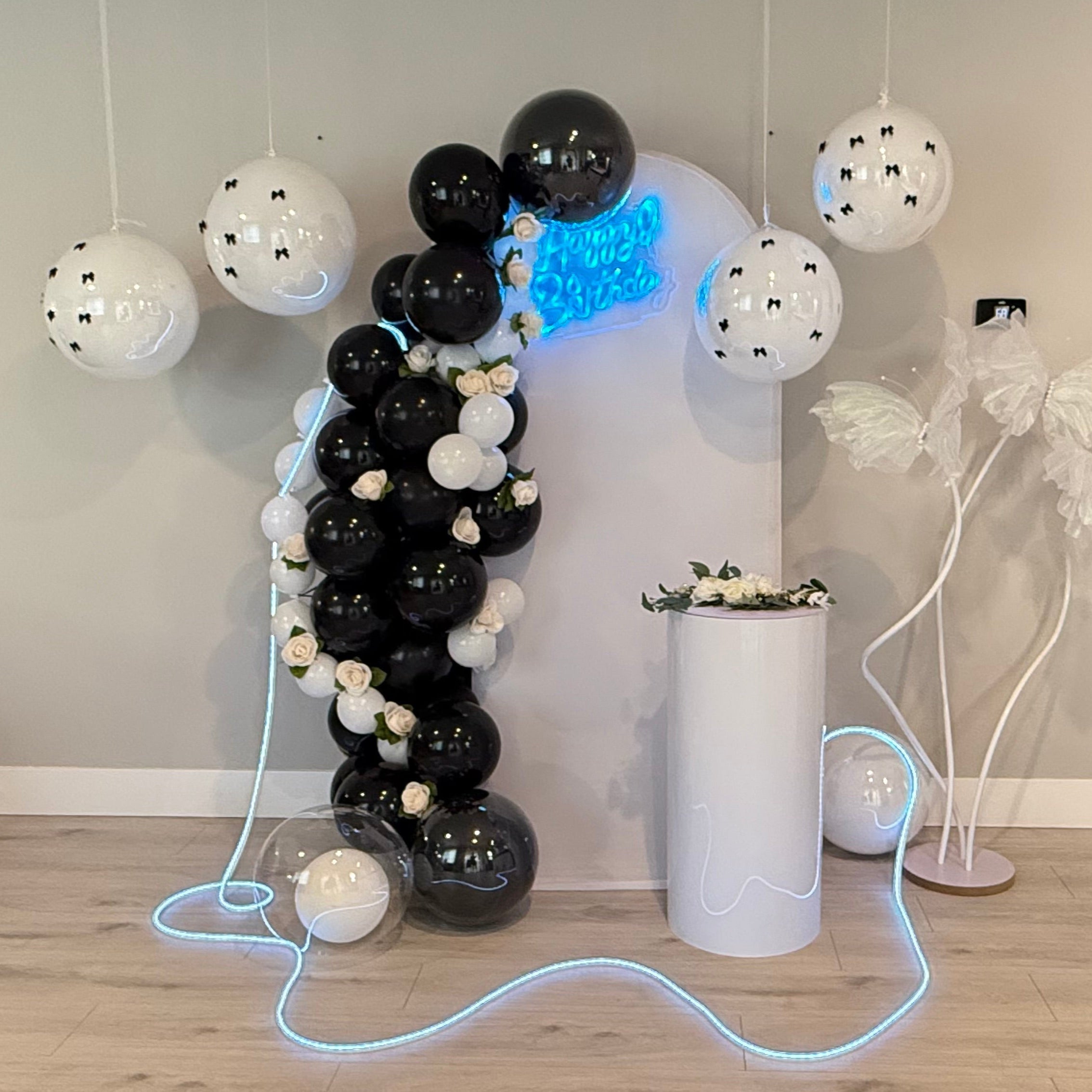 Black and white balloon arch with roses and custom birthday decoration setup